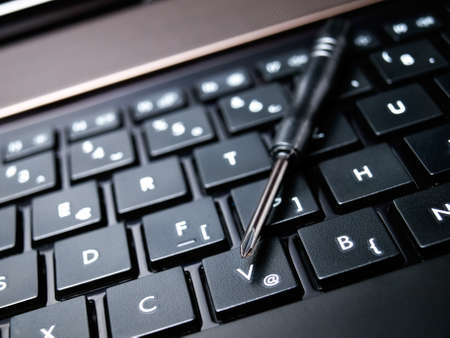 Conceptual view of computer service shown with a screwdriver and keyboard.の写真素材