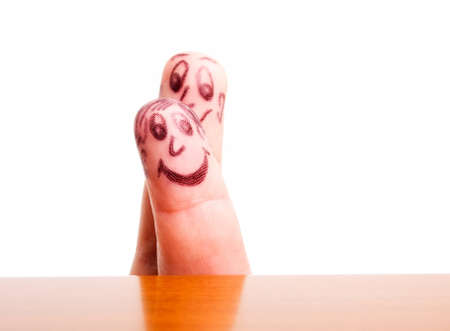 Faces drawn on fingers on a white background.