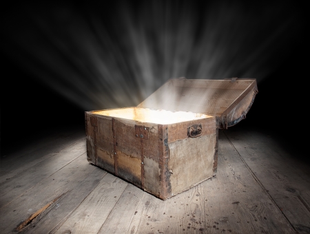 Ancient wooden treasure chest with the strong glow from inside  の写真素材