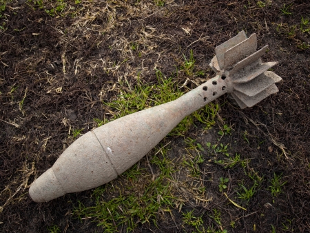 Old unexploded mortar shell grenade on the ground.の写真素材
