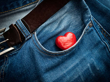 Red heart in the pocket of jeans trousers.の写真素材