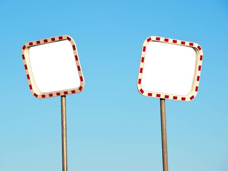 Two blank road mirros on a blue sky background.の写真素材