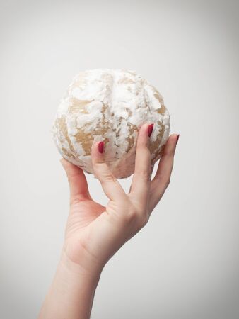 Woman holds the peeled pomelo on a neutral background
