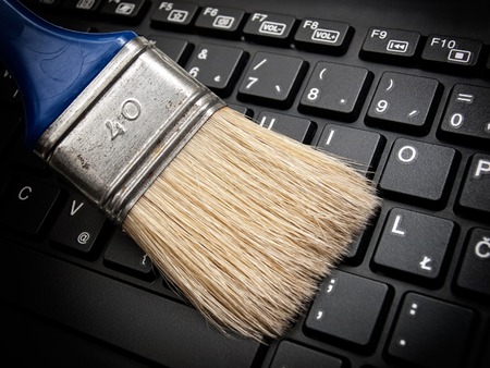 The brush cleans the computer keyboard as a concept of maintaining digital data.の写真素材