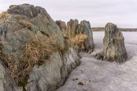 frozen rocks stick out from under the ice