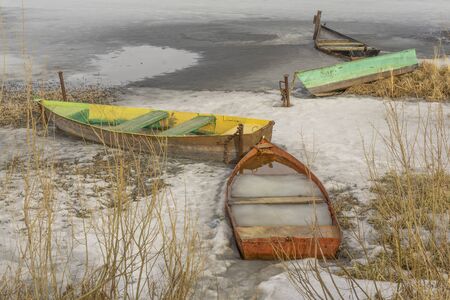 boats in ice on a frozen pond lake riverの写真素材