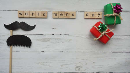 World mens day. lettering cleaning mask mustache gifts heart on a beautiful backgroundの写真素材