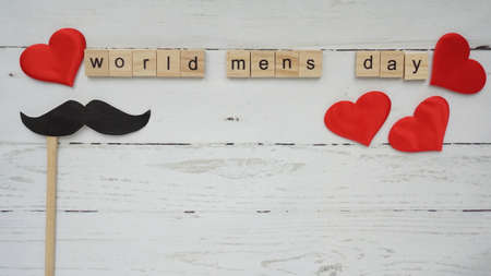 World mens day. lettering cleaning mask mustache gifts heart on a beautiful backgroundの写真素材