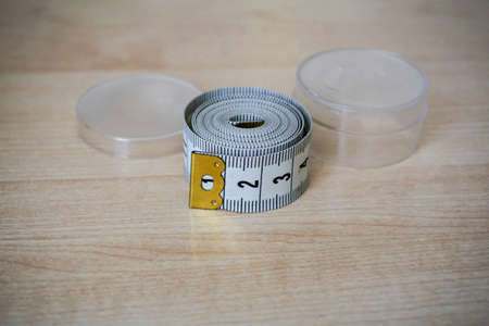 Tape measure for a seamstress on a wooden backgroundの写真素材