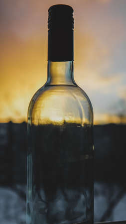 an empty wine bottle at sunset photoの写真素材