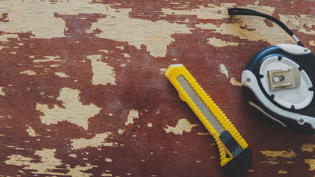 a tape measure and a stationery knife are on the table