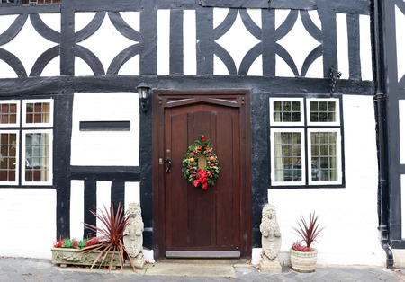 Close up of Brown Door with Christmas Wreath on Traditional Black and White Tudor Style Houseのeditorial素材