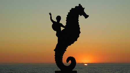 Silhouette Of Child Riding A Seahorse On Sunset, Puerto Vallarta, Mexicoの写真素材