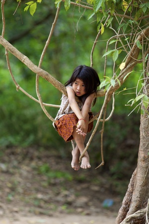 Siem Reap, Cambodia- April 1, 2011: Unidentified child plays in jungle at Ta Prohm Temple in Siem Reap, Cambodia on April 1, 2011のeditorial素材