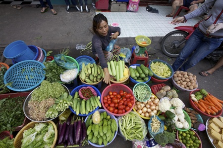 Ho Chi Minh City, Vietnam- Circa June 2010: Street Vendor in Ho Chi Minh City, Vietnam selling vegetables on the sidewalkのeditorial素材