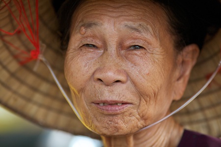Duong Lam Village, Vietnam- September 3, 2010: Unidentified older Vietnamese woman wears traditional hat on September 3, 2010 in Duong Lam Village, Vietnam.のeditorial素材