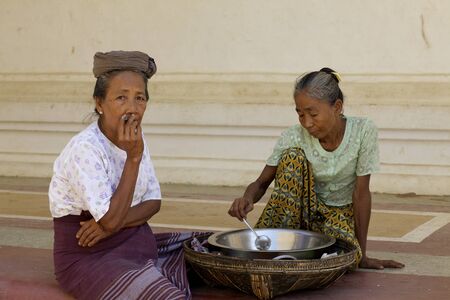 Bagan, Myanmar - Oct 15: Unidentified women smoking cheroot and preparing soup in Bagan, Myanmar on October 15, 2011.のeditorial素材