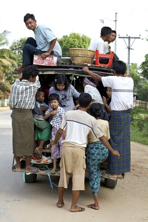 Bagan, Myanmar - Oct 14: A truck overcrowded with passengers loads up on road in Bagan, Myanmar on October 14, 2011.のeditorial素材