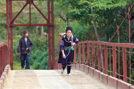 SAPA, VIETNAM- NOV 21: Unidentified woman of the Black Hmong Ethnic Minority People walks across bridge in Sapa, Vietnam on November 21, 2010. のeditorial素材