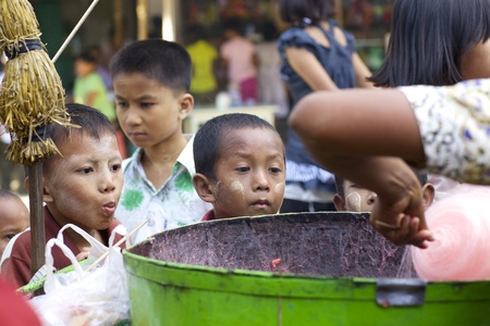 BAGAN, MYANMAR- OCT 14: Unidentified young children look on as cotton candy is being spun in Bagan, Myanmar on October 14, 2011.のeditorial素材