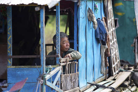 SIEM REAP, CAMBODIA-JAN 23: A Cambodian man on his floating house on Tonle Sap Lake in Siem Reap, Cambodia on January 23, 2012. のeditorial素材