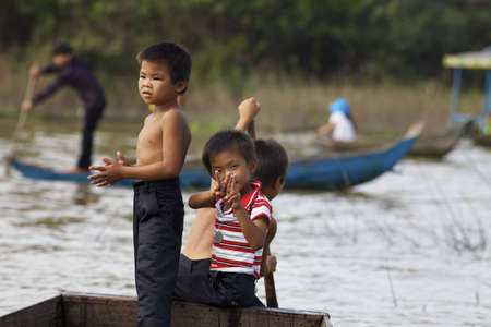 Siem Reap, Cambodia - Jan 23, 2012: Three Cambodian children row their boat on Tonle Sap Lake in Siem Reap, Cambodia on January 23, 2012.のeditorial素材