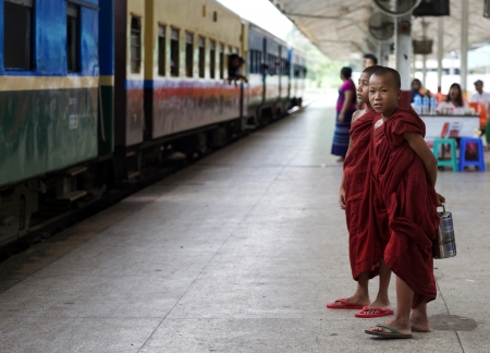 Yangon, Myanmar- July 28: Two unidentified young novice monks waiting on the train at the Central Railway Station in Yangon, Myanmar on July 27, 2013. のeditorial素材