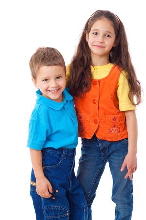 Two smiling little children standing together, isolated on whiteの写真素材