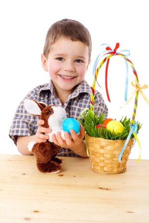 Smiling boy playing with easter eggs and bunny, isolated on whiteの写真素材