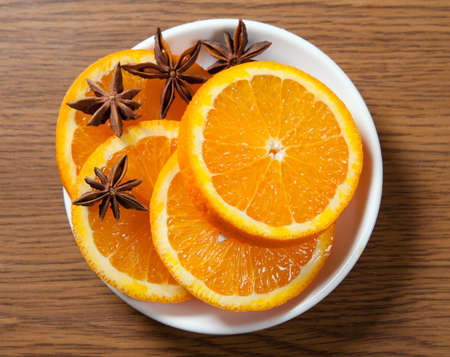 Sliced orange with anise on the saucerの写真素材