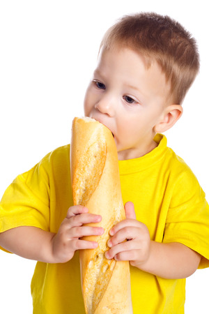 Little boy eating the french baguette, isolated on whiteの写真素材