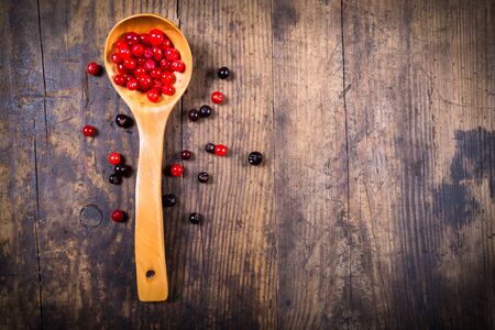viburnum in spoon and black currant on wooden background with empty copy spaceの写真素材