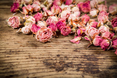Closeup of dried rose flowers on wooden backgroundの写真素材