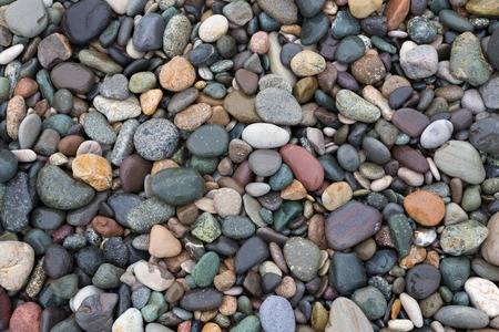 Closeup of colorful wet pebbles on the beach, natural background.