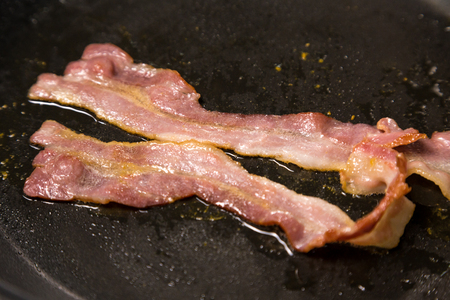 fried bacon on hot panの写真素材