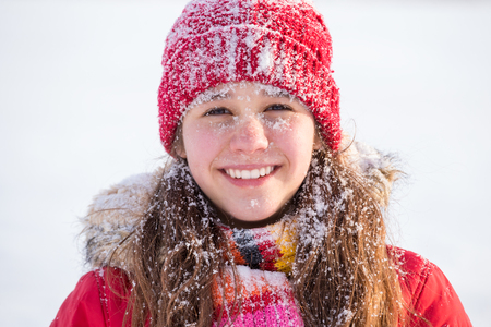 Happy girl with snow on face at winter landscapeの写真素材