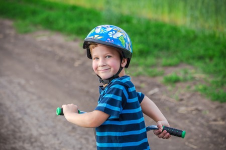 Portrait of little boy with his bike on country roadの写真素材