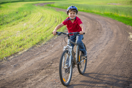 boy ride on bike at rural roadの写真素材