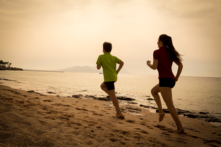 Two kids running together at morning exersises, sepia tonedの写真素材