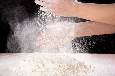 chefs hand clapping with powder flour when kneading the doughの写真素材