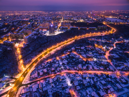 Evening aerial view to residential area Zhuravlivka and Zhuravlivskyi descent road in Kharkiv with snow, Ukraineの写真素材