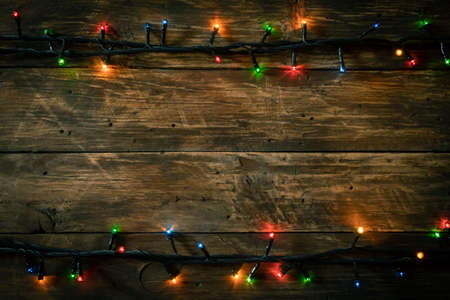 Dark festive wooden background with electric garland lamp - christmas decorationの写真素材