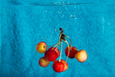 cherries splashing in water