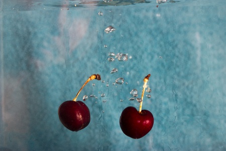 cherries splashing in waterの写真素材