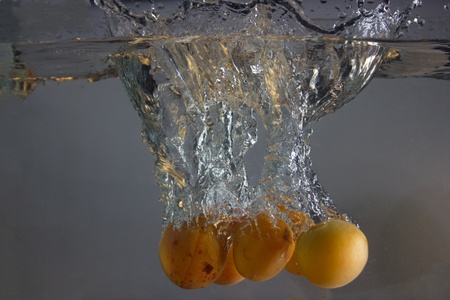 Apricot splashing in water の写真素材