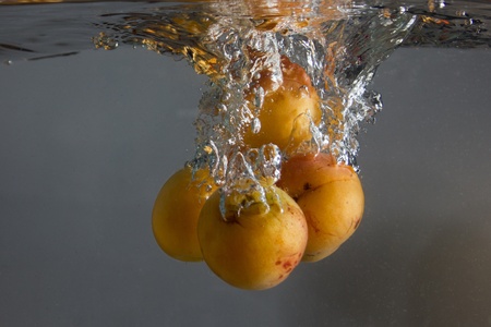 Apricot splashing in water の写真素材
