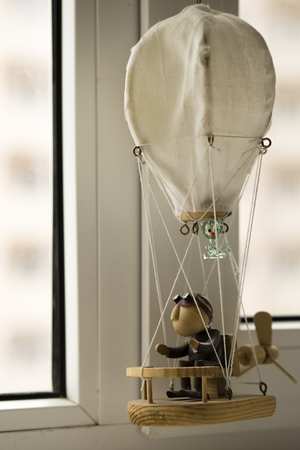 Wooden puppet, with a cat, in a balloon, looking out the window.の写真素材