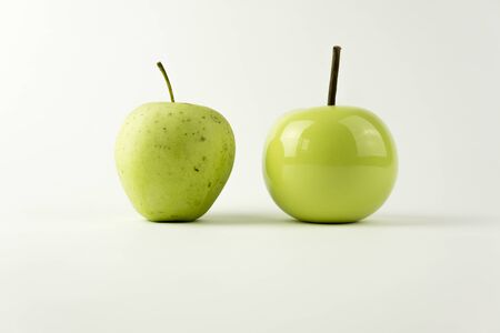 A natural apple versus and a ceramic appleの写真素材