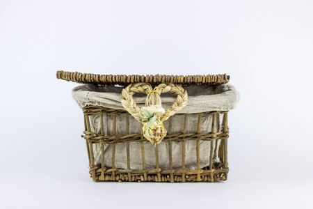 Rattan wooden box on a white background, with a heart weaved from strawsの写真素材
