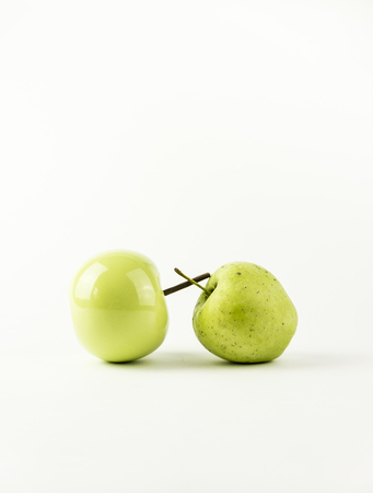 A natural apple versus and a ceramic appleの写真素材